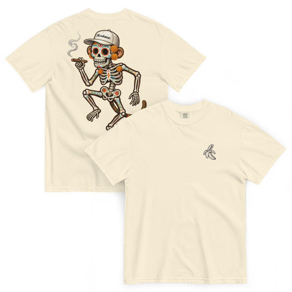 Two ivory-colored t-shirts shown on a white background, displaying the front and back designs. The back shirt features a large graphic of a cartoon skeleton with orange-brown bones, a white baseball cap, and a cigar.