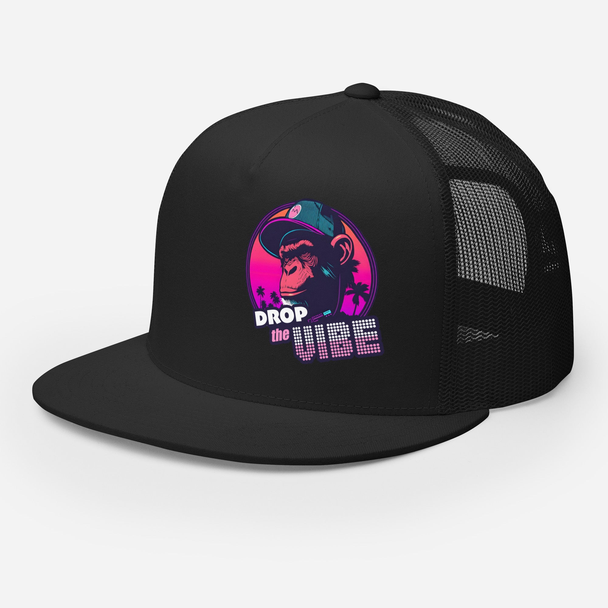 A black Monksee "Drop the Vibe" trucker cap with a mesh back, displayed flat against a white background, showing front and left side. The front features a graphic of a cap-wearing monkey against a sunset with palm trees, with "DROP the VIBE" in bold pink and white text below it. The back has a plain mesh panel with a snapback closure.
