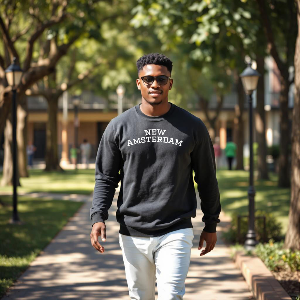Man wearing a 'New Amsterdam' sweatshirt walking on a tree-lined path.