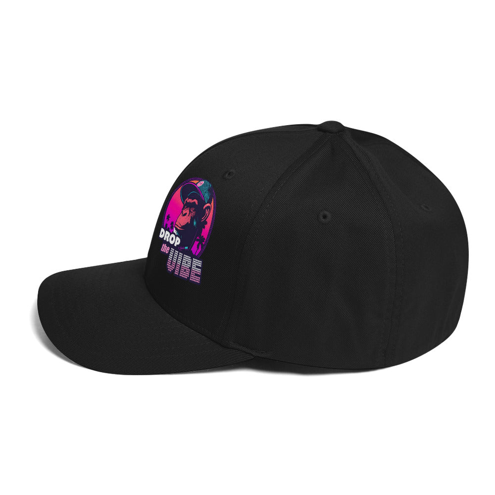 Left side of the monksee drop the vibe closed back black cap sitting on white background. Front Drop the Vibe logo slightly visible on front left