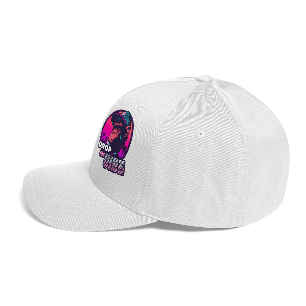 Left side of the monksee drop the vibe closed back white cap sitting on white background. Front Drop the Vibe logo slightly visible on front left