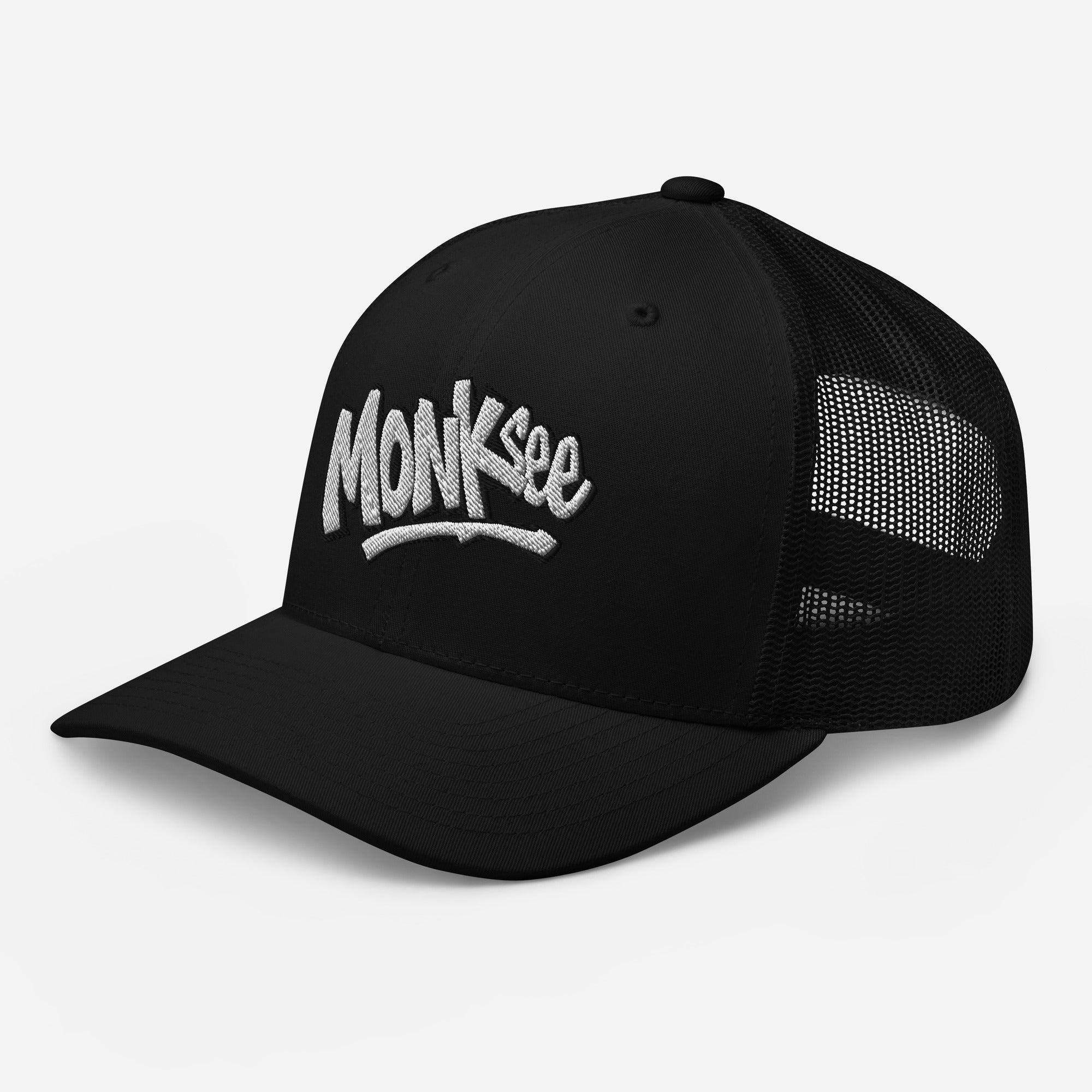 left front view of monksee kick flip trucker cap with embroidered logo on white background