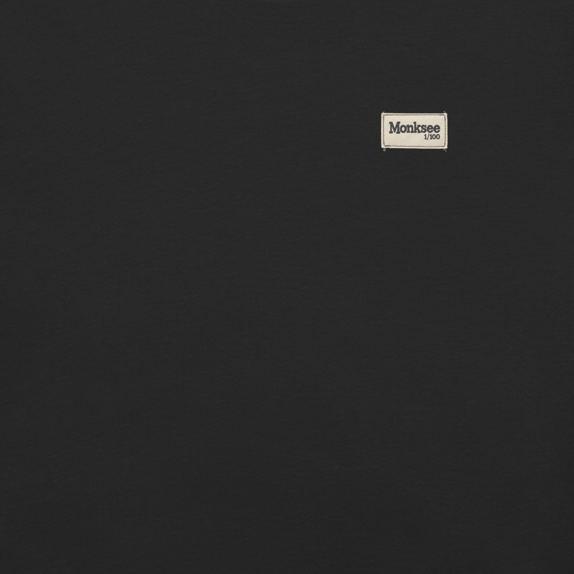 Monksee white 1/100 label on a black background