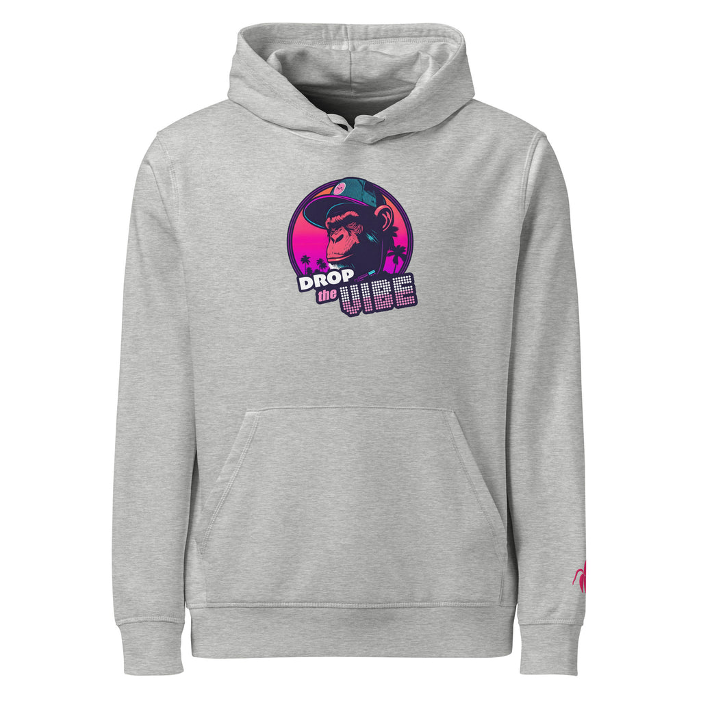 A grey Monksee "Drop the Vibe" hoodie displayed flat against a white background. It features a neon graphic of a cap-wearing monkey against a sunset with palm trees, with "DROP the VIBE" in bold pink and white text. A small pink Monksee banana logo is on the left sleeve.