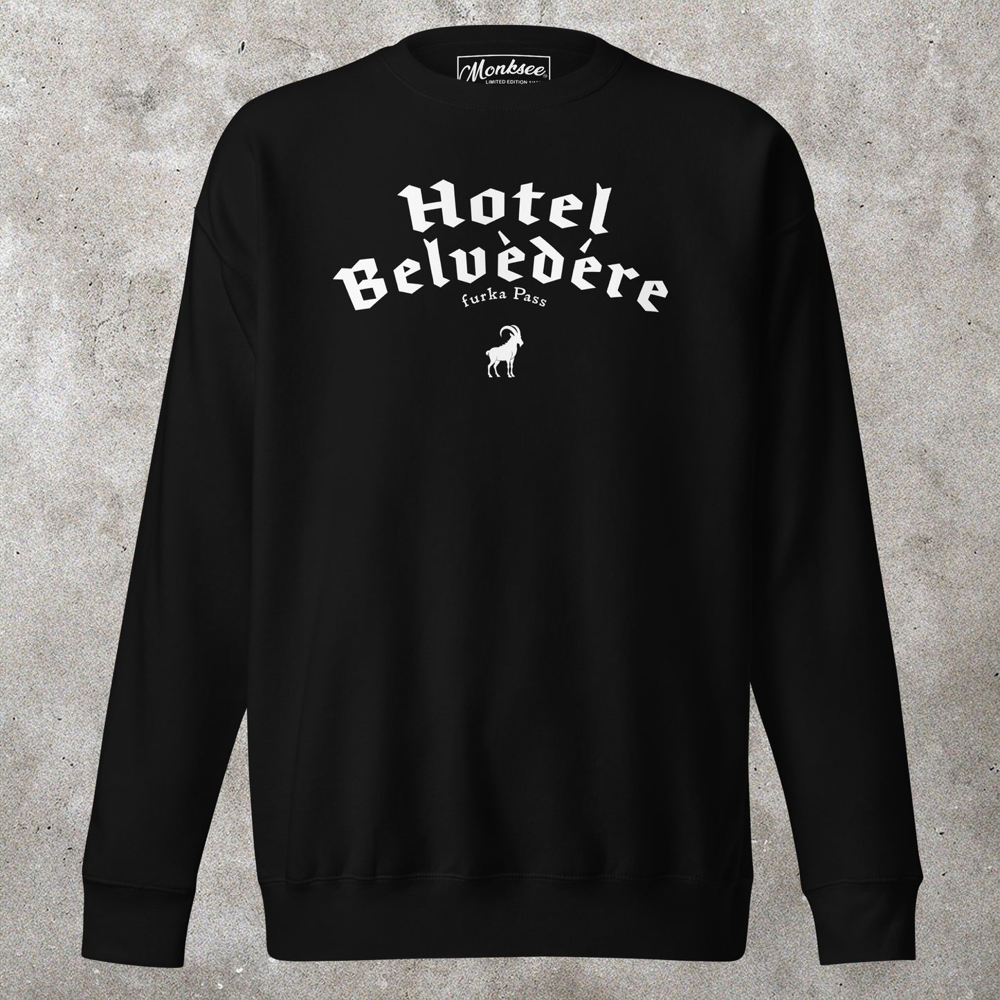 Black sweatshirt with 'Hotel Belvedere' text on a concrete surface