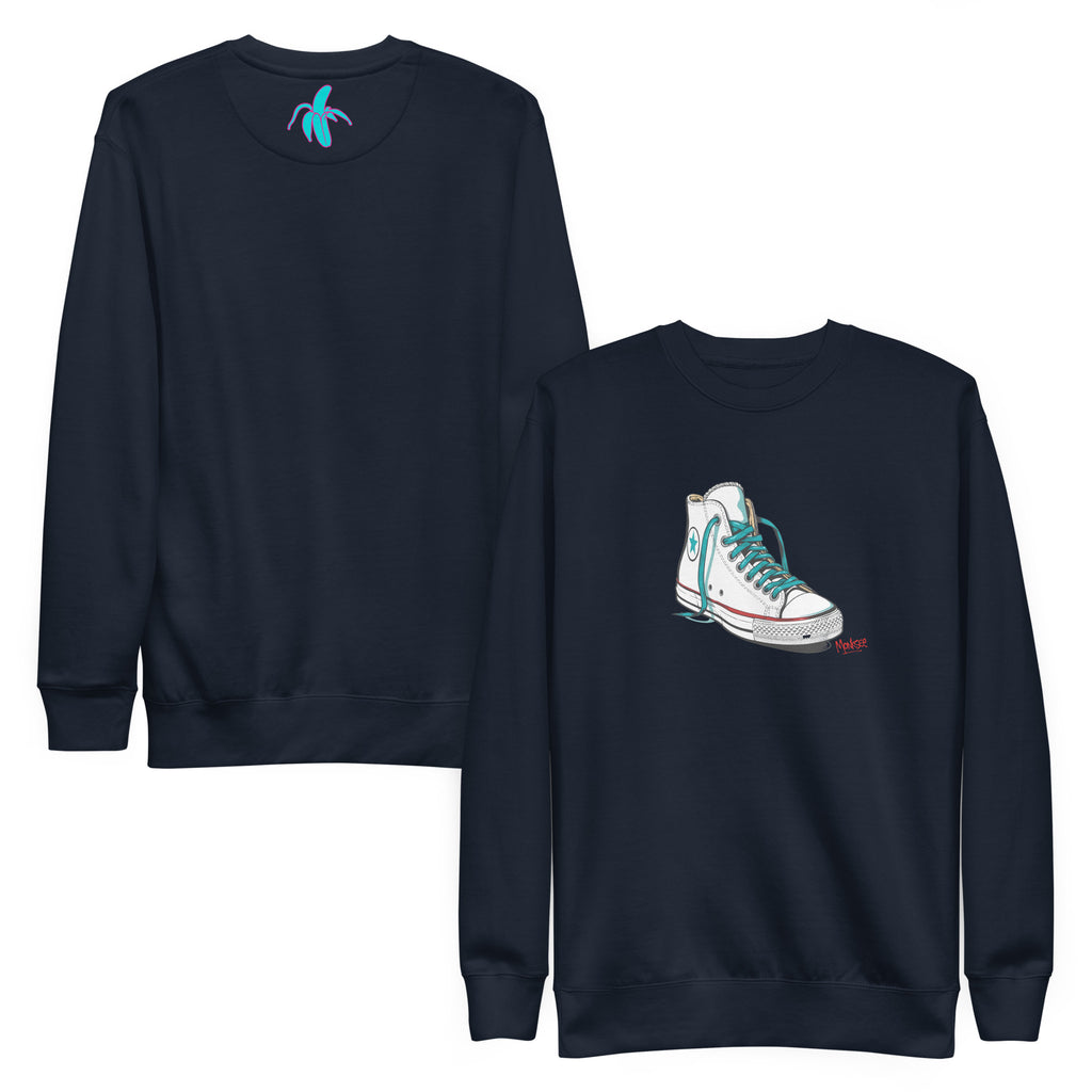 A navy blue Monksee "Kickin It!" sweatshirt displayed front and back against a white background. The front features a white sneaker graphic with blue laces. A blue Monksee logo is on the back neck.