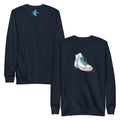 A navy blue Monksee "Kickin It!" sweatshirt displayed front and back against a white background. The front features a white sneaker graphic with blue laces. A blue Monksee logo is on the back neck.