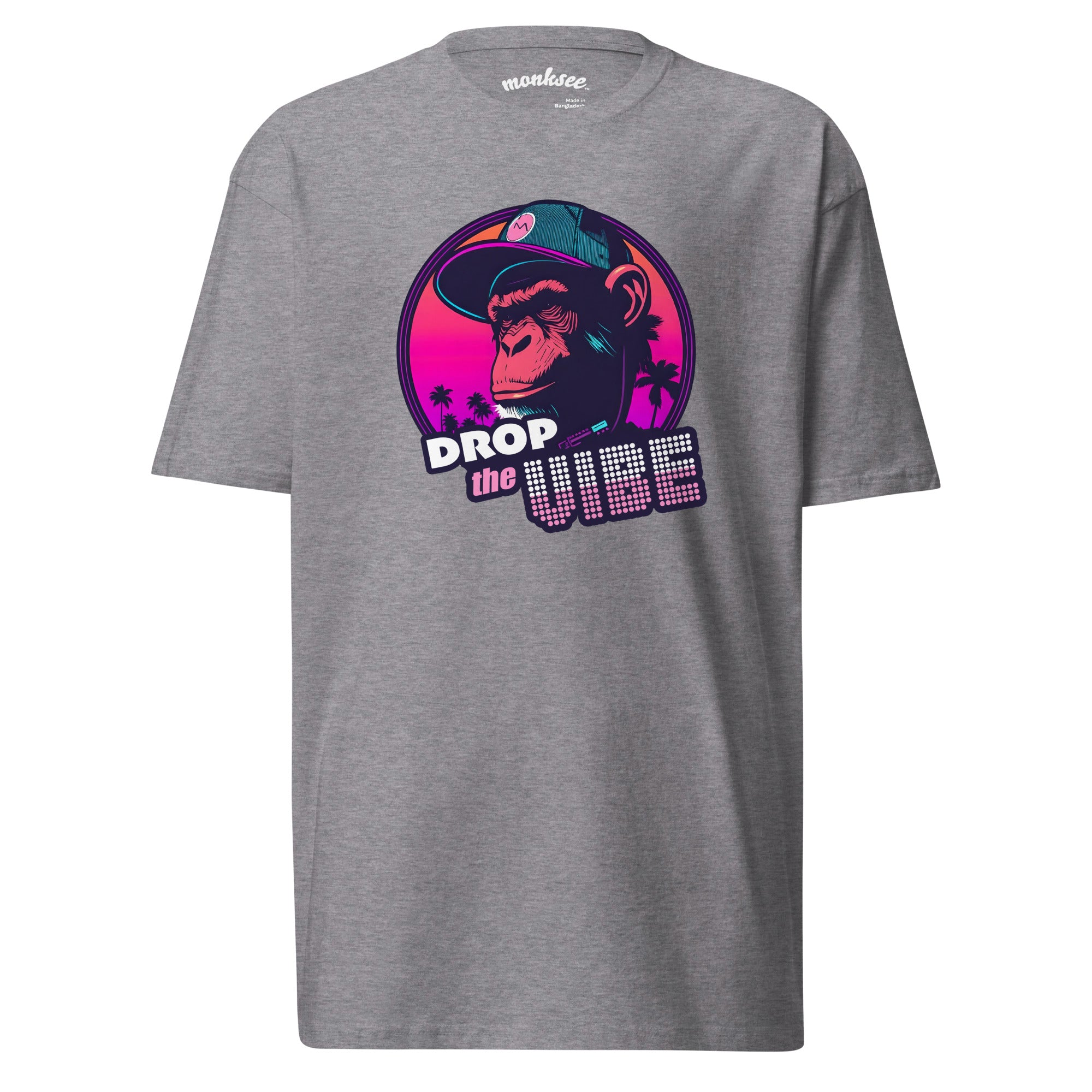 athletic grey Monksee "Drop the Vibe" t-shirt displayed flat against a white background. It features a neon graphic of a cap-wearing monkey against a sunset with palm trees, with "DROP the VIBE" in bold pink and white text. The Monksee banana is on the back neck