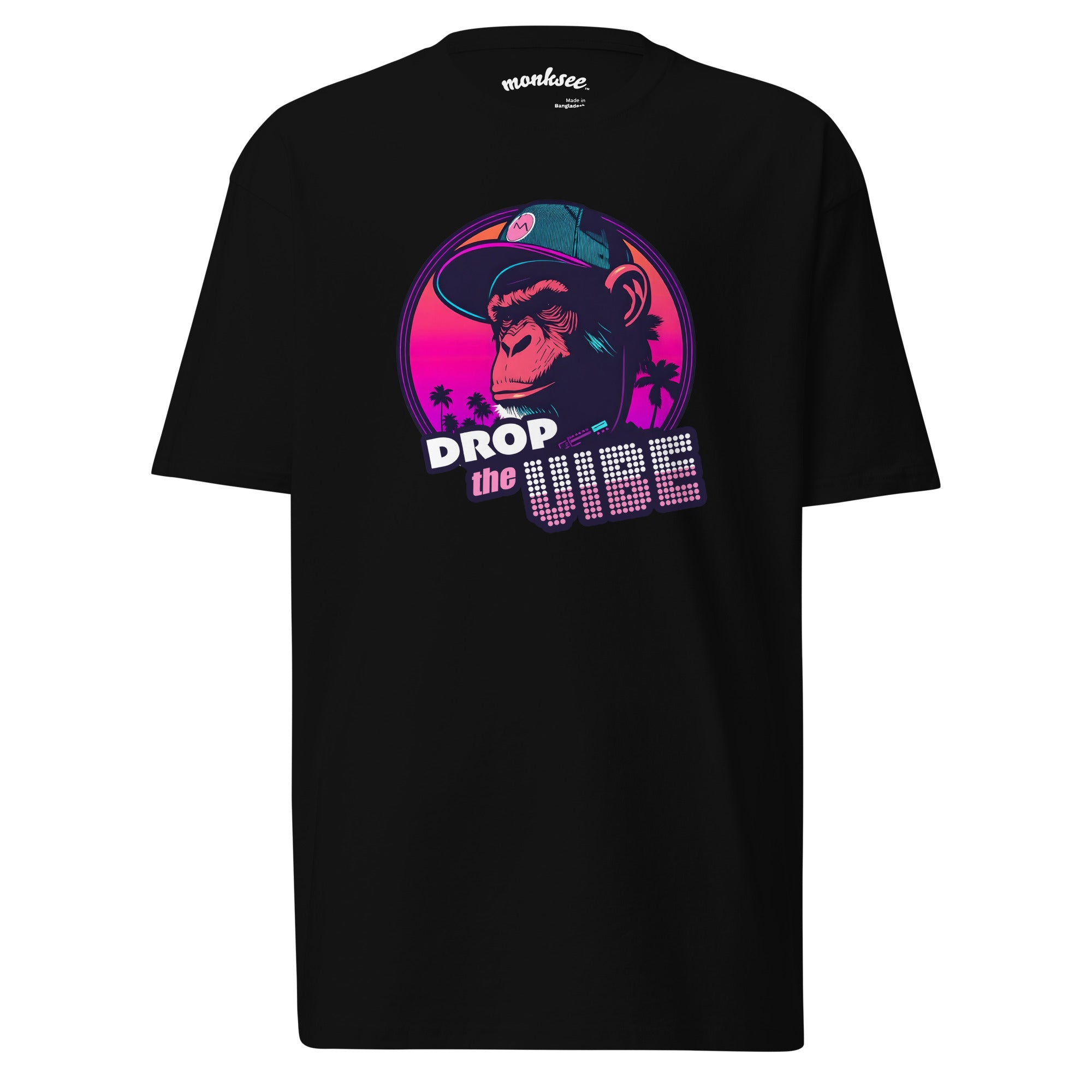A black Monksee "Drop the Vibe" t-shirt displayed flat against a white background. It features a neon graphic of a cap-wearing monkey against a sunset with palm trees, with "DROP the VIBE" in bold pink and white text. The Monksee banana is on the back neck.