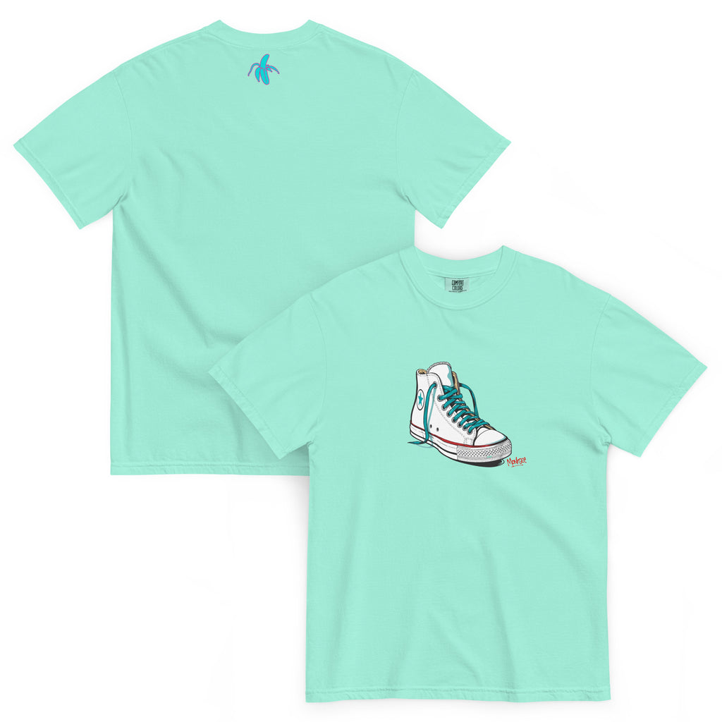 an image of the front and back of the monksee kickin it chalky mint tshirt featuring artistic drawing of a chuck Taylor Allstars shoe on the front and the teal and pink monksee banana on the back