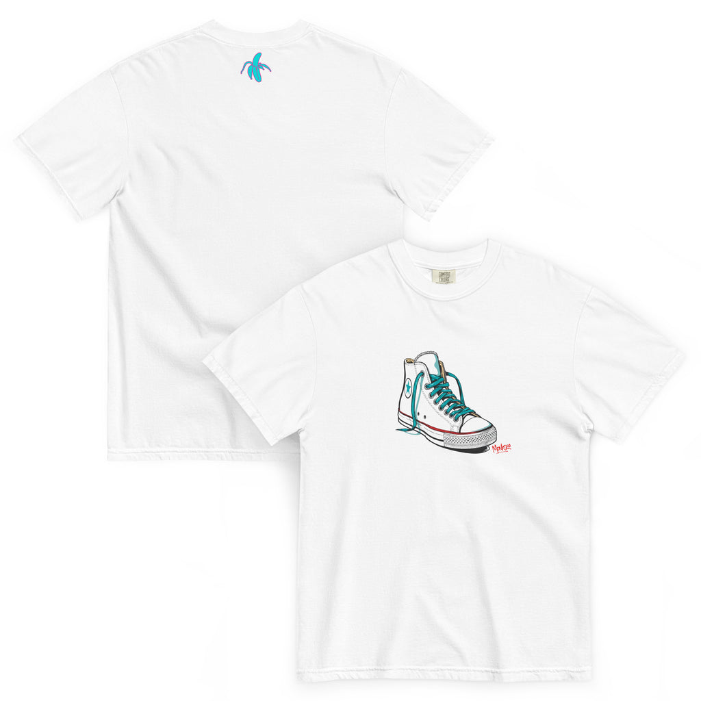an image of the front and back of the monksee kickin it white tshirt featuring artistic drawing of a chuck Taylor Allstars shoe on the front and the teal and pink monksee banana on the back
